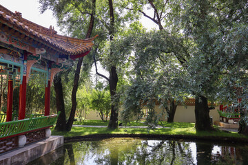  A serene Asian garden featuring a peaceful pond, lush greenery, and traditional design elements, evoking calm and reflection.