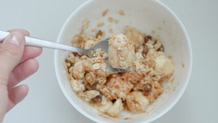 Healthy oatmeal breakfast with banana slices and cinnamon on white table
