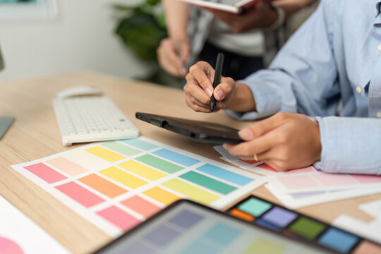 Creative Process in UX and UI Design. Designer working on a tablet with color swatches.
