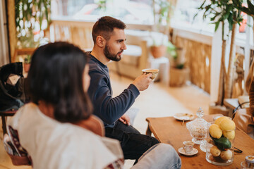 Two people engage in a comfortable conversation while enjoying coffee together in a warmly lit cafe...