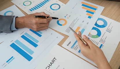 Analyzing Financial Data. Close-up of hands reviewing charts and graphs during a business meeting.