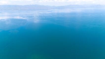 Aerial view of a tropical island with white sand beaches and volcanic features, captured by drone. Chayeri Island, Sevan, Armenia