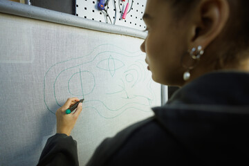 African american craftswoman drawing on rug canvas in workshop
