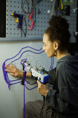 African american craftswoman making rug with tufting gun in workshop
