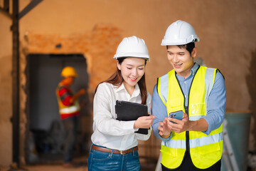 Engineer teams meeting working together wear worker helmets hardhat on construction site. Asian industry professional team.