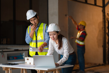 Engineer teams meeting working together wear worker helmets hardhat on construction site. Asian industry professional team.