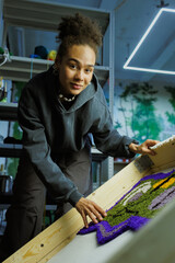 African american craftswoman looking at camera near handmade rug