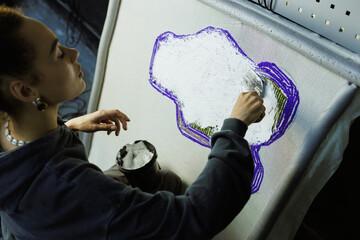 African american craftswoman applying backing glue on rug