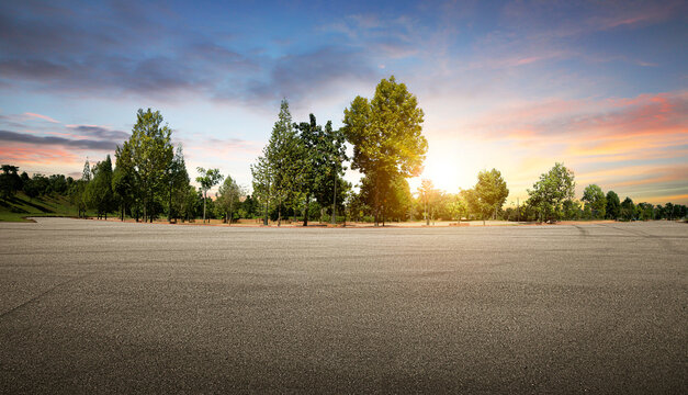 Panoramic empty asphalt road in the park during sunset.