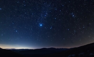 Starry night sky over dark mountains