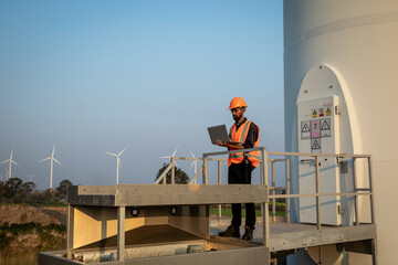 Young Engineer or Maintenance Technician Working with Laptop Computer on Wind Farm