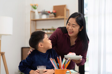 Obraz premium Back to School and Family Bonding. A mother shares a treat with her son, celebrating their time together.