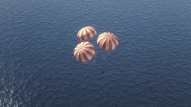 Reentry space capsule descending toward the ocean with three parachutes. Splashdown.