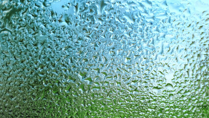 Water Drops on a glass. Dripping rain drops textured background. Close up of misted window with...