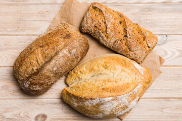 Assortment of freshly baked bread with napkin on rustic table top view. Healthy unleavened bread. French bread