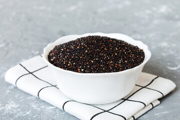 quinoa seeds in bowl on colored background. Healthy kinwa in small bowl. Healthy superfood
