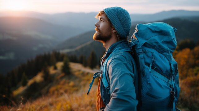 Hiker enjoying a sunset view while resting on a mountaintop with a backpack