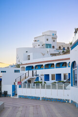 Coastal promenade in Sidi Ifni showcasing blue and white architecture at sunset