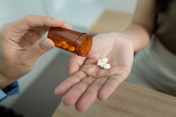 Medication Dispensing. Healthcare worker pouring pills from bottle into patient hand.
