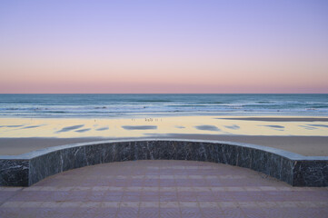 Majestic view of Sidi Ifni beach at sunset with soft waves and colorful sky