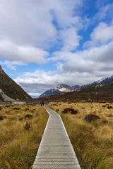 Papier peint photo  Wooden boardwalk trail through Hooker Valley with mountain views in Aoraki/Mount Cook National Park, New Zealand  © Jay J. Lee
