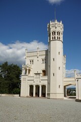 Fototapeta premium Historic white castle with tall tower under blue sky.