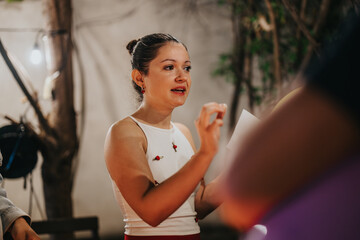 An engaged woman expresses an idea during an outdoor interaction surrounded by a natural setting.