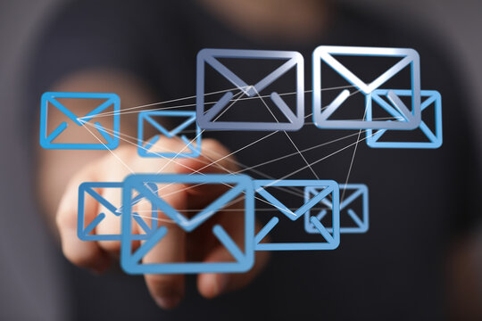 Hand interacting with digital email icons, representing global communication and networking.