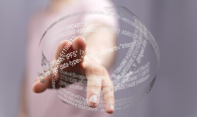 Close-up of a hand interacting with a digital hologram displaying lines of code and data.
