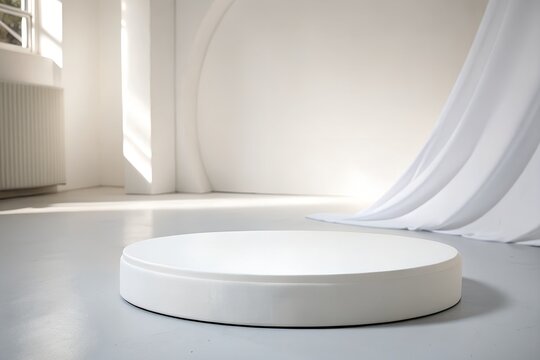 White circular minimalist pedestal in softly lit indoor studio podium