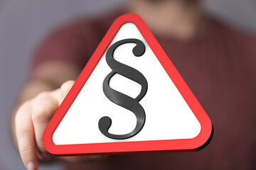 Legal warning concept.  Hand points to a red triangle with a paragraph symbol.
