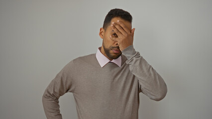 Young man with hand on forehead isolated over white background looks thoughtful wearing casual...