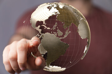 High-quality stock photo of a hand interacting with a digital globe, representing global...