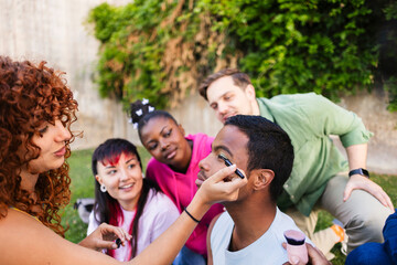 Make up artist applying eyeliner to young man in a park
