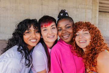Four young women smiling and having fun together outdoors
