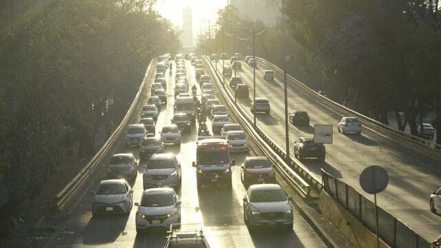Ambulance navigating through congested highway traffic at sunset