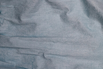 Fabric texture showcases soft woven design in shades of blue with subtle wrinkles and variations