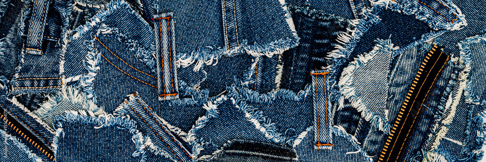 Aufkleber various denim fabric pieces with frayed edges and contrasting stitching lying flat on a surface