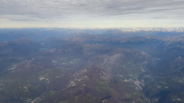 Aerial view of Parco dei Colli di Bergamo, Italy, showing rolling hills, lush woodlands, and mountain views under a clear sky, a peaceful natural escape near the city of Bergamo