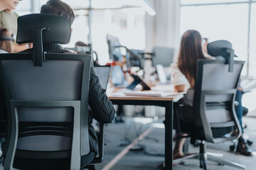 A contemporary office setting showcasing diverse employees in a collaborative environment. The image captures open space, ergonomic seating, and technology fostering teamwork and productivity.