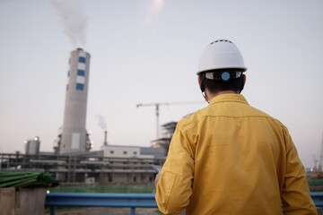 asian male engineer working  with digital tablet in oil refinery