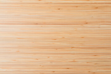 High angle view of a natural light brown bamboo wood surface texture showing the grain and natural patterns suitable for backgrounds