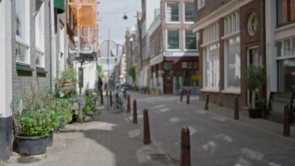 Blurred view of a european street in a quiet town, showcasing brick buildings and an empty road, capturing an outdoor urban atmosphere with clear sky and soft focus.