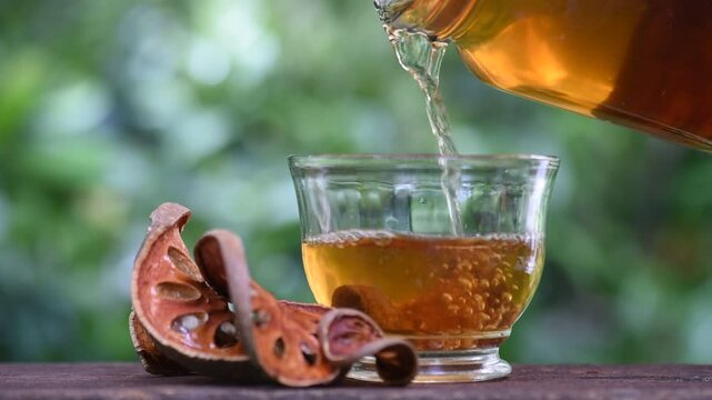 Dried beal slices are brewed into a healthy tea drink on natural background.
