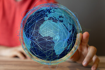 Abstract image of a hand interacting with a digital globe, representing global connectivity and...