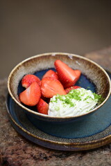 Fresh strawberries with mascarpone cheese served as fresh fruit – vibrant and creamy dessert with elegant food background
