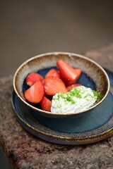 Fresh strawberries with mascarpone cheese served as fresh fruit – vibrant and creamy dessert with elegant food background