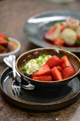 Close-up of fresh ripe strawberries placed on a rustic wooden table, highlighting the vibrant red color and natural texture