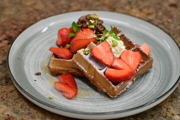 Portion of golden waffles (gofry) served on a plate, showcasing their crispy texture and inviting appearance