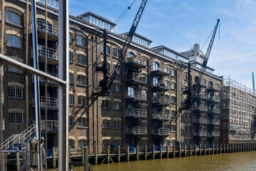 London, UK,  7 May 2025,  New Concordia Wharf. Historic Riverside Buildings with Cranes in London.